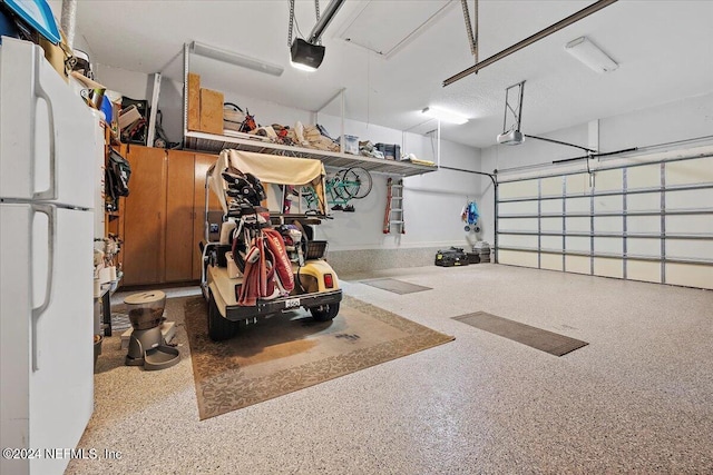 garage with a garage door opener and white fridge