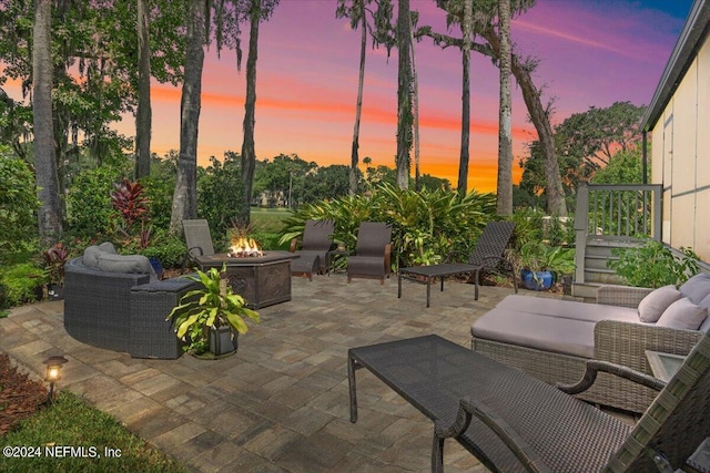 patio terrace at dusk with an outdoor living space with a fire pit