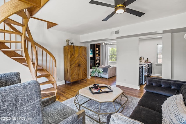 living room with sink, wood-type flooring, and ceiling fan