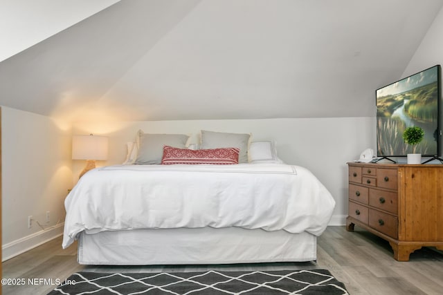 bedroom featuring vaulted ceiling and light hardwood / wood-style flooring