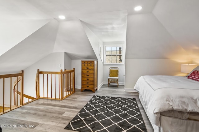 bedroom with lofted ceiling and wood-type flooring