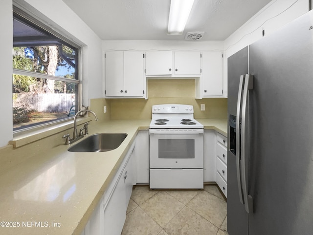 kitchen with sink, stainless steel fridge with ice dispenser, light tile patterned floors, white range with electric cooktop, and white cabinets