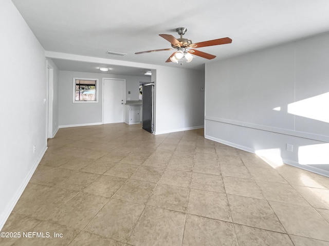 tiled spare room featuring ceiling fan