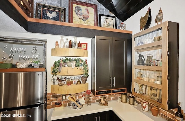 interior space featuring lofted ceiling and stainless steel refrigerator