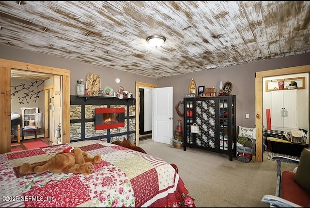 bedroom featuring wood ceiling, light colored carpet, and a fireplace