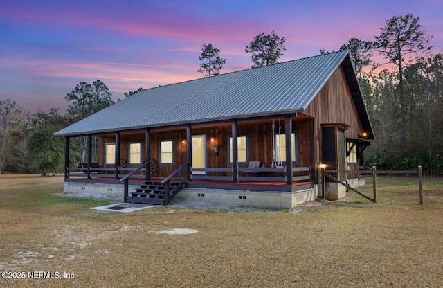 view of front of property with a porch and a lawn