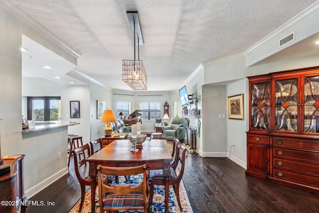 dining area with ornamental molding, dark hardwood / wood-style floors, and a textured ceiling