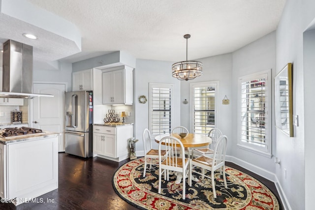 dining space with a textured ceiling, dark wood-type flooring, and a chandelier