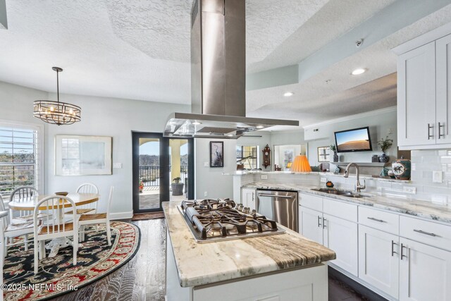 kitchen featuring island range hood, white cabinetry, sink, light stone counters, and stainless steel appliances