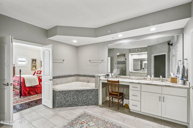 bathroom with vanity, tiled bath, and tile patterned flooring