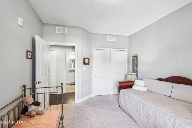 bedroom with light colored carpet, a closet, and a textured ceiling