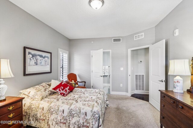 bedroom featuring ensuite bath and carpet flooring