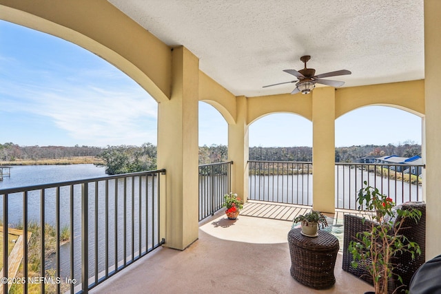 balcony with a water view and ceiling fan