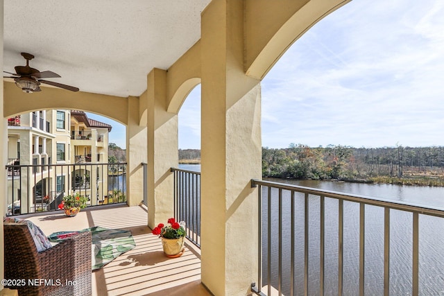 balcony featuring a water view and ceiling fan