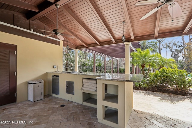 view of patio featuring ceiling fan and exterior kitchen