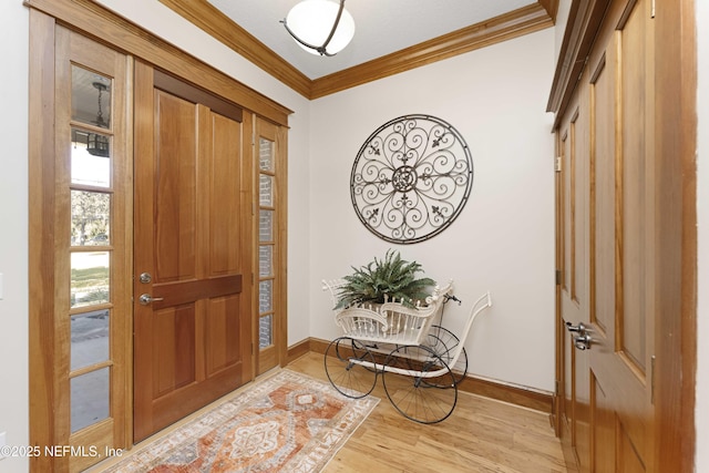 foyer entrance with light hardwood / wood-style flooring and ornamental molding