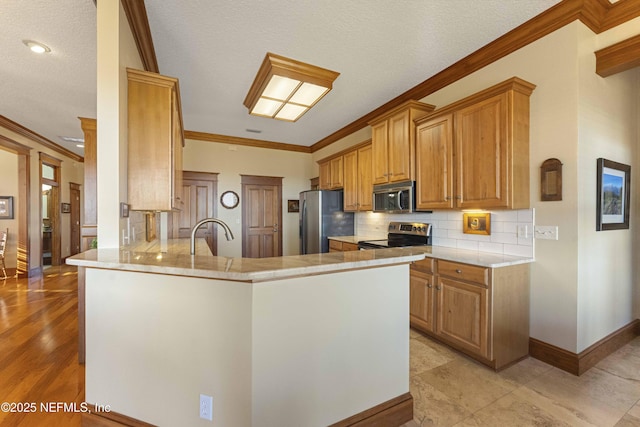 kitchen with ornamental molding, stainless steel appliances, and kitchen peninsula