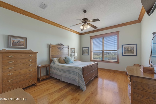 bedroom with ceiling fan, ornamental molding, a textured ceiling, and light wood-type flooring