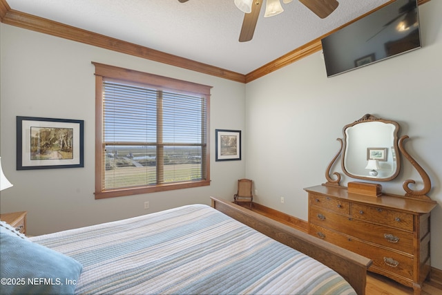 bedroom featuring a textured ceiling, wood-type flooring, ornamental molding, and ceiling fan