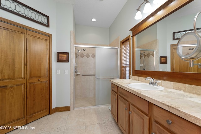 bathroom with walk in shower, tile patterned floors, and vanity