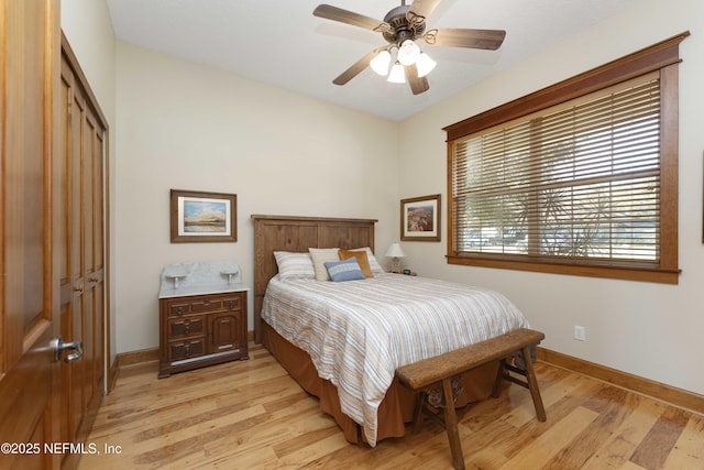 bedroom with ceiling fan, light wood-type flooring, and a closet