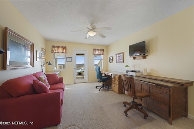 carpeted office featuring ceiling fan and a textured ceiling