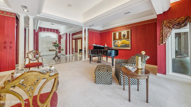 living area featuring ornamental molding, decorative columns, and light carpet