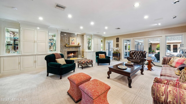 carpeted living room featuring a high end fireplace and ornamental molding