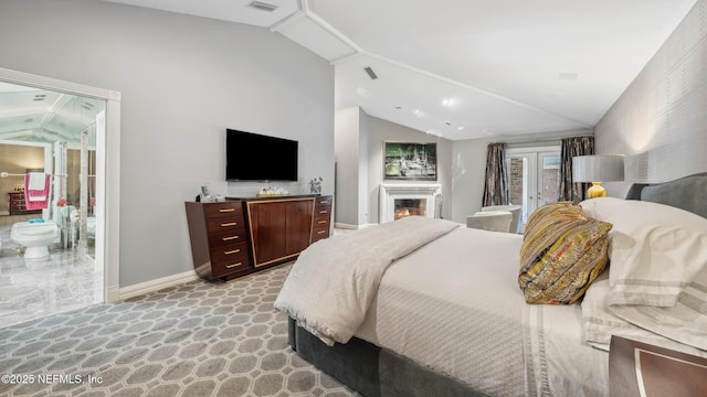 bedroom with vaulted ceiling, connected bathroom, and french doors