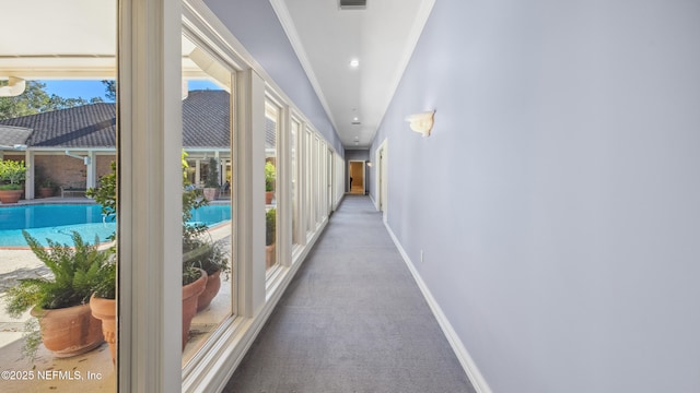 hall featuring ornamental molding and carpet