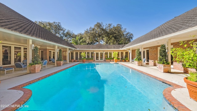 view of swimming pool featuring a patio and french doors