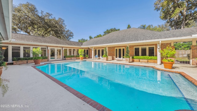 view of swimming pool with a patio and french doors