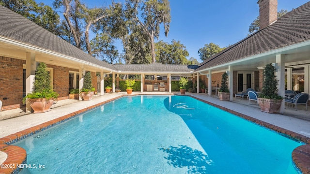 view of pool with french doors and a patio area