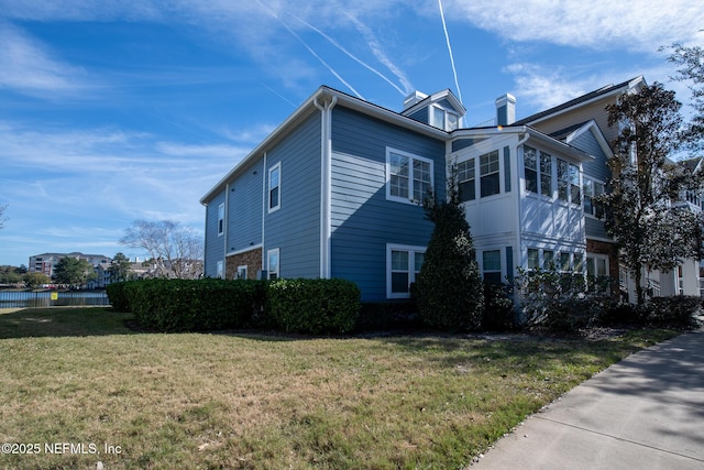 view of side of home with a yard