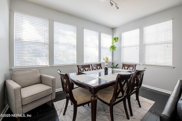 dining space featuring track lighting and dark hardwood / wood-style floors