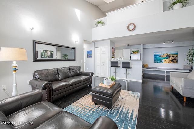 living room with a high ceiling and dark wood-type flooring