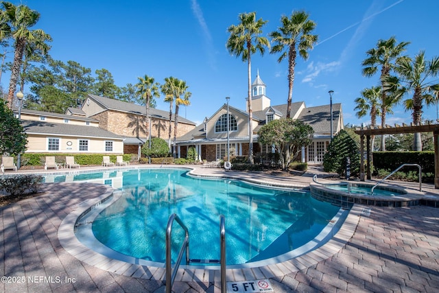 view of pool with a hot tub, a pergola, and a patio area