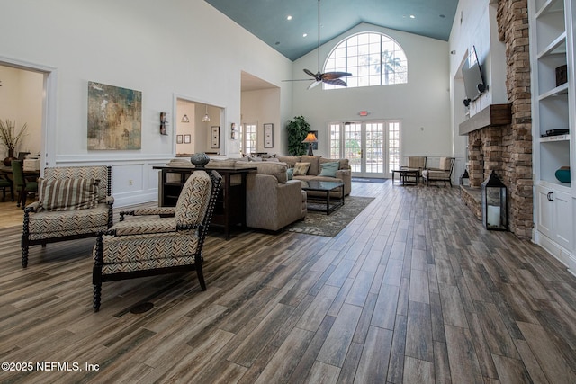 living room with high vaulted ceiling, built in features, dark hardwood / wood-style floors, and ceiling fan