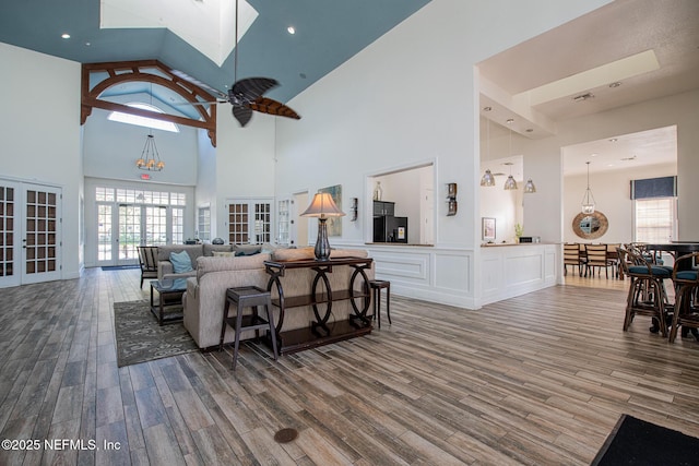 living room featuring french doors, wood-type flooring, and a notable chandelier