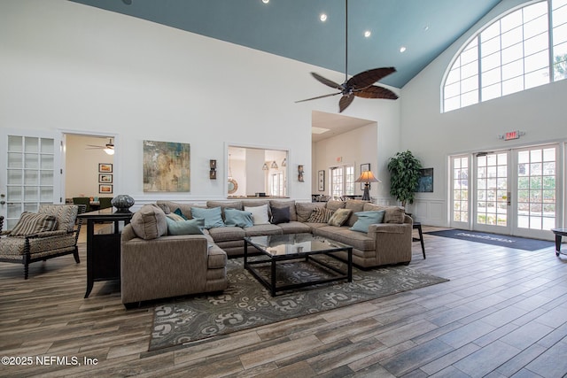 living room featuring wood-type flooring, ceiling fan, and french doors