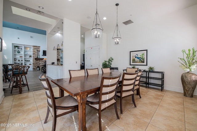 dining area featuring light tile patterned floors and a high ceiling