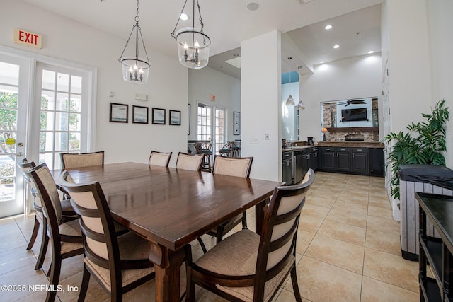 dining area featuring a notable chandelier, a high ceiling, and light tile patterned flooring