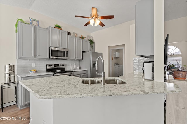 kitchen featuring gray cabinets, appliances with stainless steel finishes, sink, and kitchen peninsula