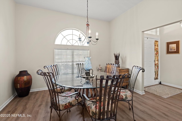 dining area with hardwood / wood-style flooring and a notable chandelier