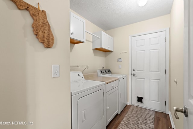 clothes washing area featuring cabinets, dark wood-type flooring, washer and dryer, and a textured ceiling