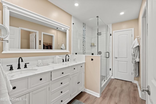 bathroom with vanity, hardwood / wood-style floors, and a shower with door