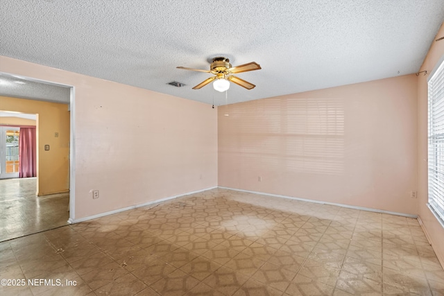 unfurnished room featuring ceiling fan and a textured ceiling