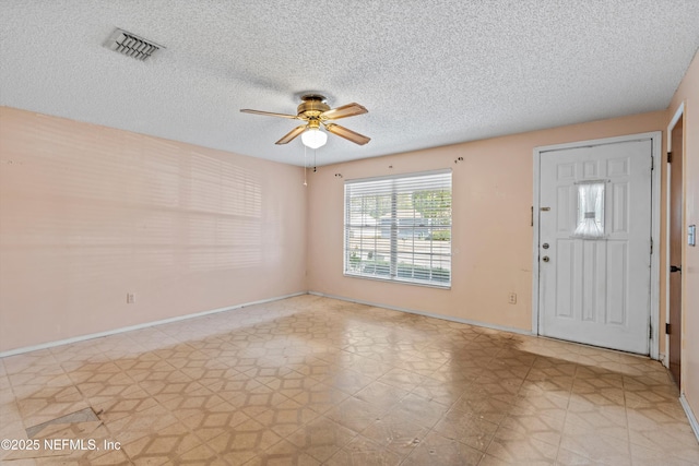 foyer entrance with a textured ceiling and ceiling fan