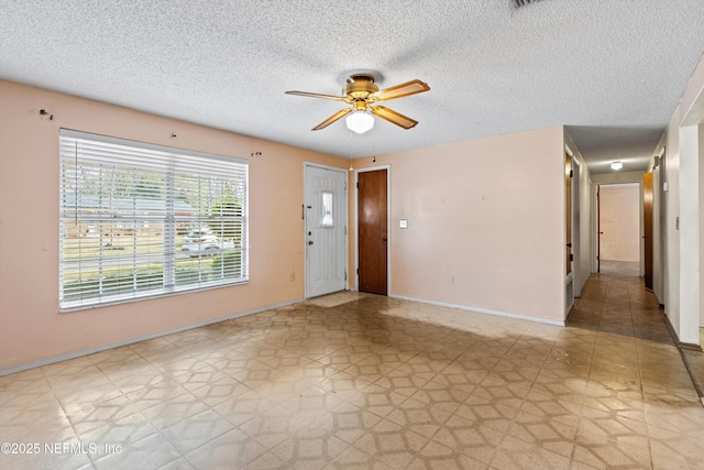 unfurnished room featuring a textured ceiling and ceiling fan