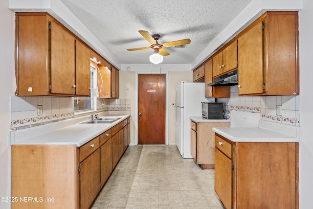 kitchen with sink, backsplash, a textured ceiling, and ceiling fan